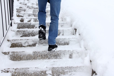 person walking on stairs that are icy